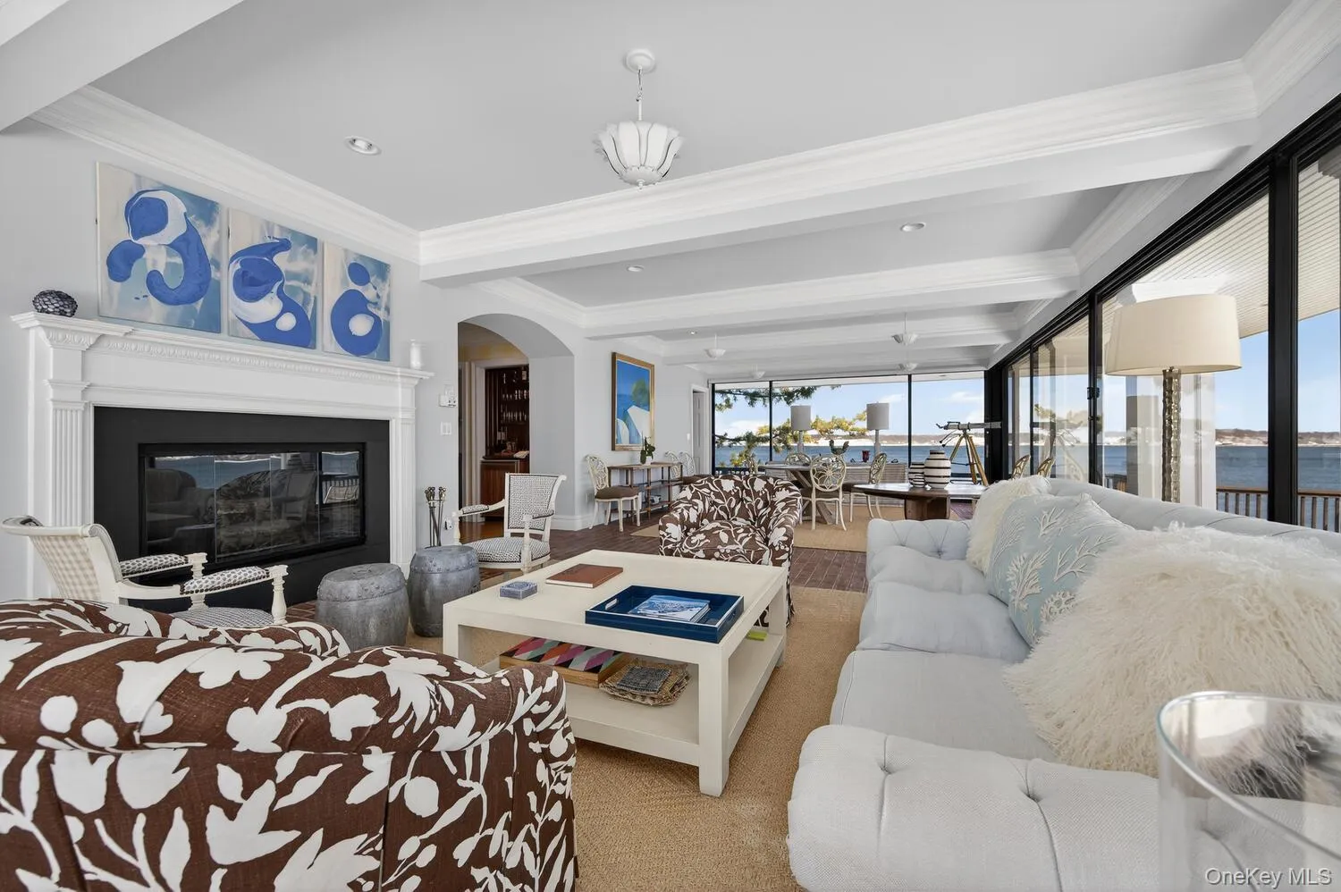 Large living/dining room with floor to ceiling doors and windows with water views Large living/dining room with floor to ceiling doors and windows with water views