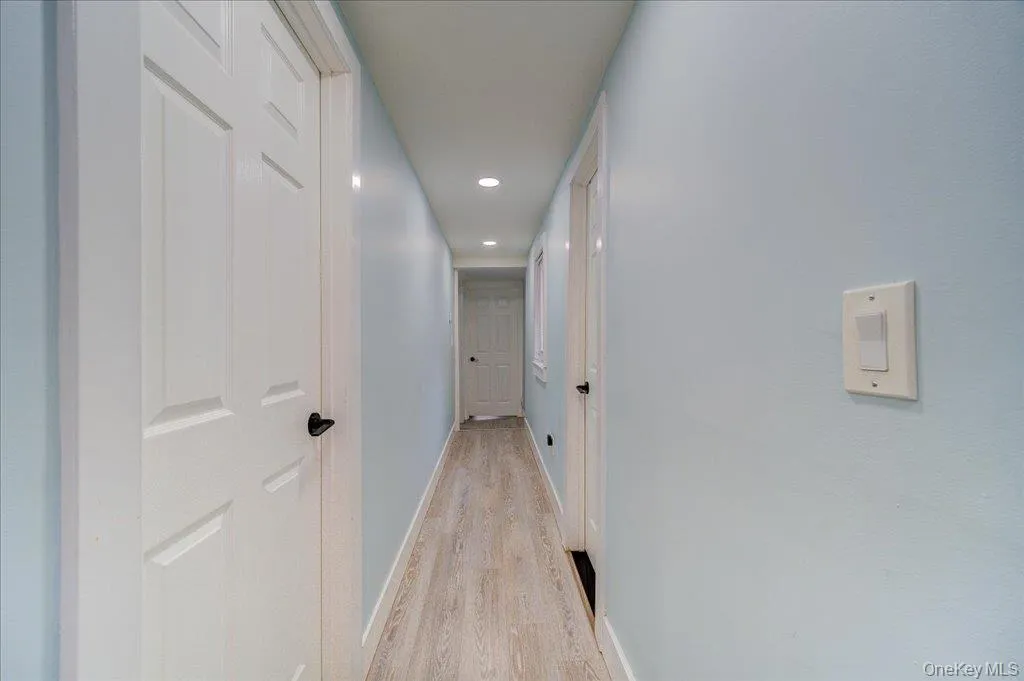 The upper level features a hallway connecting three bedrooms and a laundry room. The upper level features a hallway connecting three bedrooms and a laundry room.