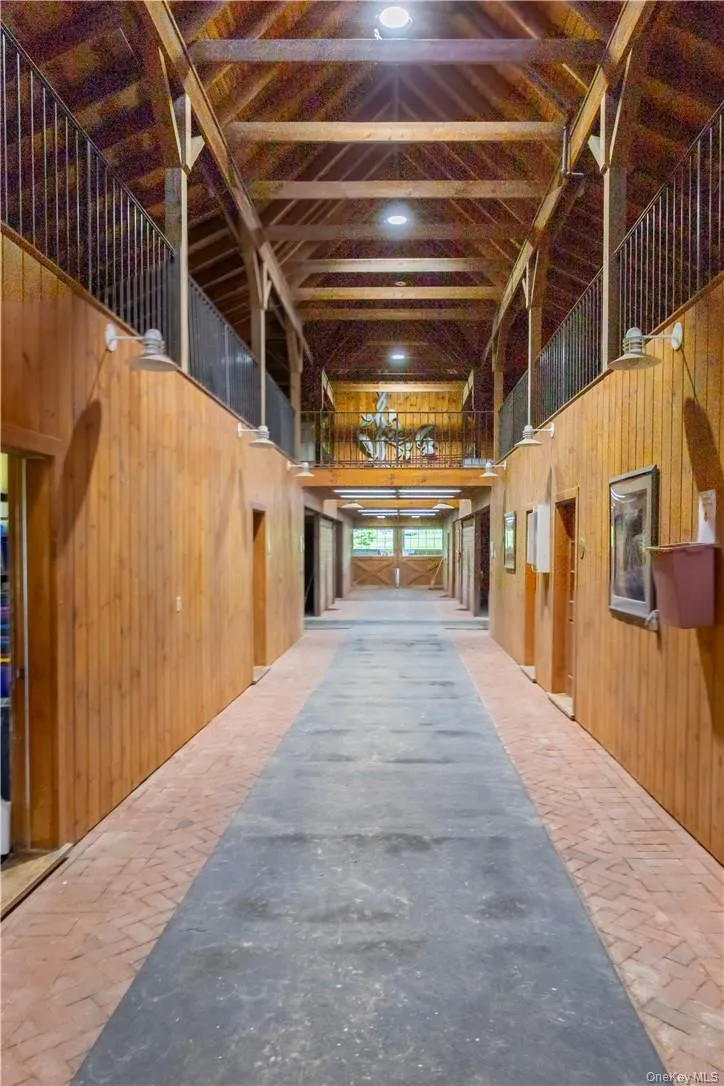The main barn center aisle, matted stalls, yoked windows, fire suppression system, automatic fly control system, climate-controlled tack room with kitchen and bathroom, feed storage, office and viewing room, bathrooms, 2 hot water wash stalls with heat lamps, 4 grooming stalls, hay loft with drop to each stall, and hay conveyor. The main barn center aisle, matted stalls, yoked windows, fire suppression system, automatic fly control system, climate-controlled tack room with kitchen and bathroom, feed storage, office and viewing room, bathrooms, 2 hot water wash stalls with heat lamps, 4 grooming stalls, hay loft with drop to each stall, and hay conveyor.