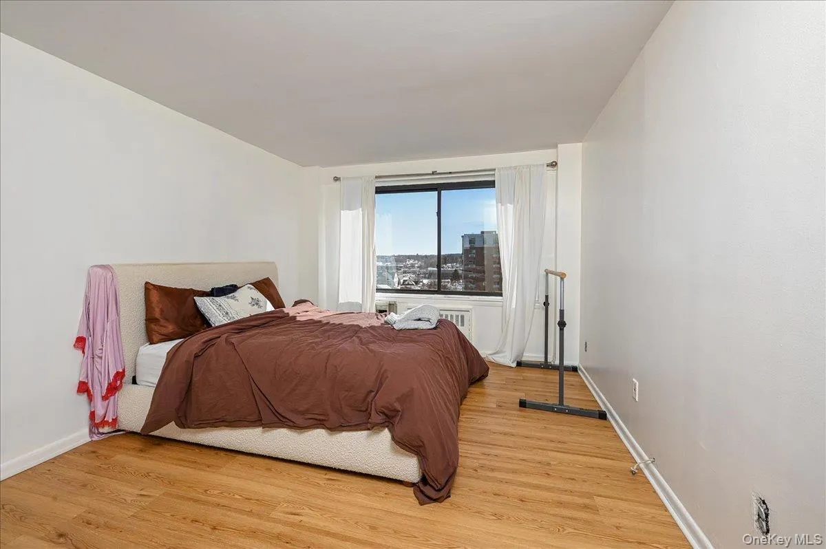 Bedroom with light wood-style flooring and baseboards Bedroom with light wood-style flooring and baseboards