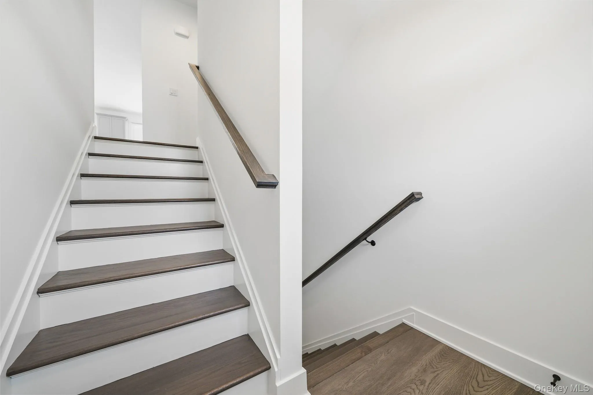 Stairway featuring wood finished floors and baseboards Stairway featuring wood finished floors and baseboards