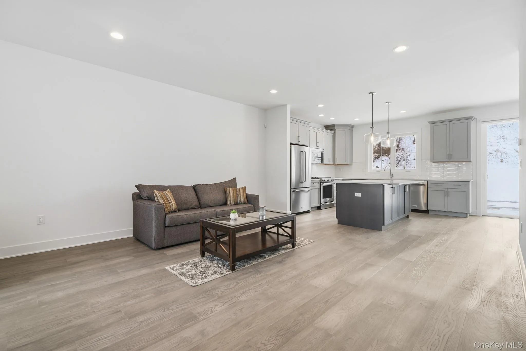 Living room with light wood-style floors and recessed lighting Living room with light wood-style floors and recessed lighting