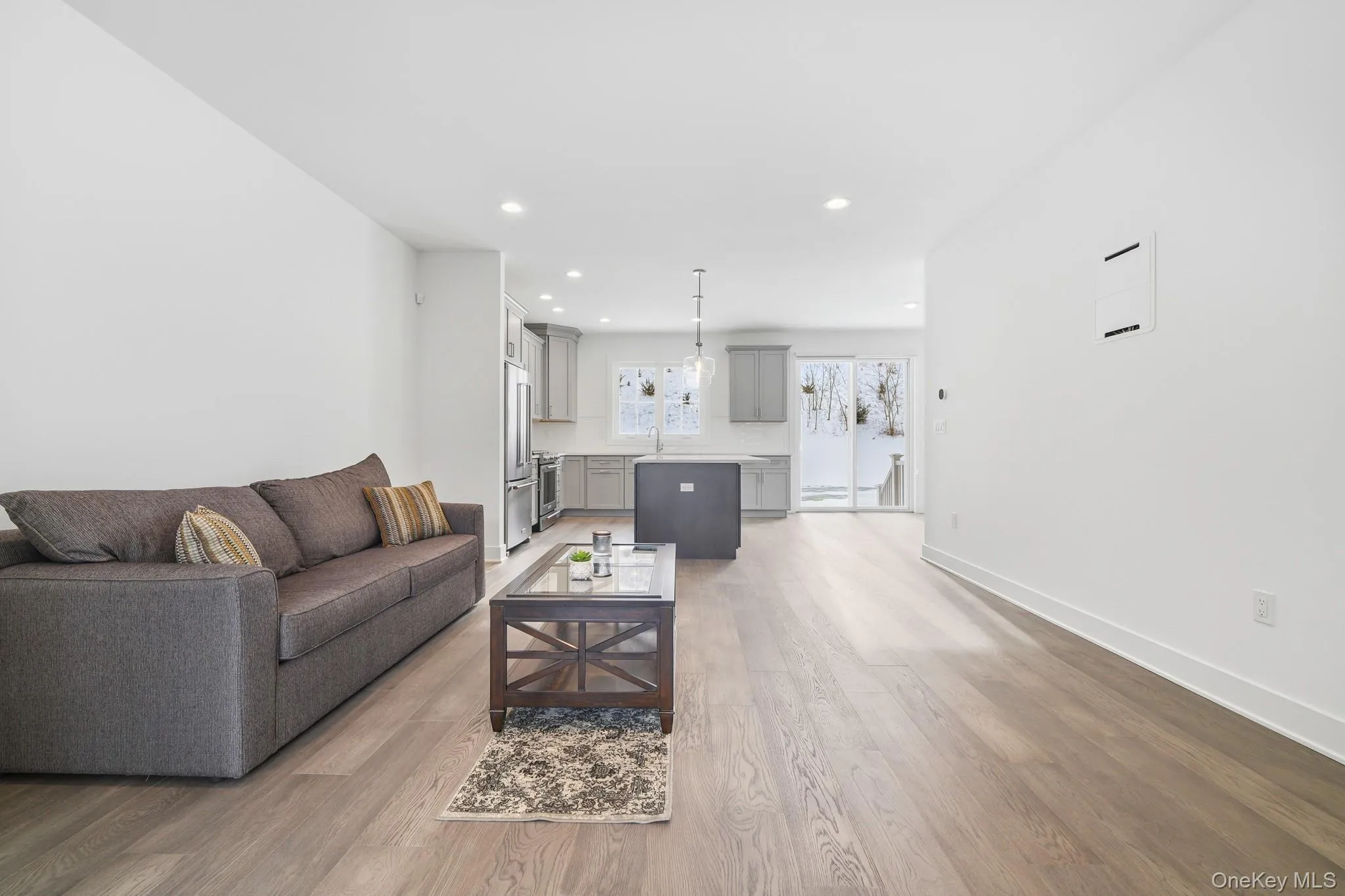Living area with light wood finished floors and recessed lighting Living area with light wood finished floors and recessed lighting