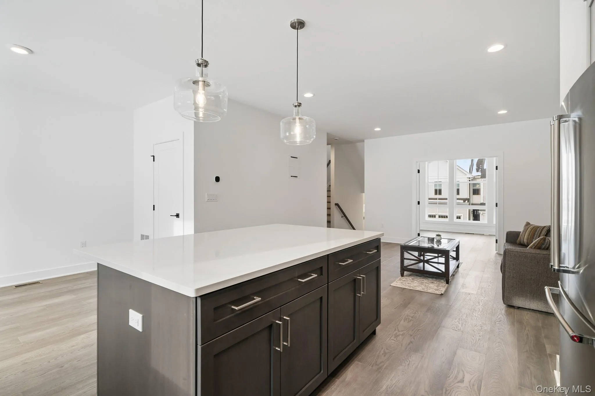 Kitchen featuring recessed lighting, a center island, hanging light fixtures, freestanding refrigerator, and open floor plan Kitchen featuring recessed lighting, a center island, hanging light fixtures, freestanding refrigerator, and open floor plan