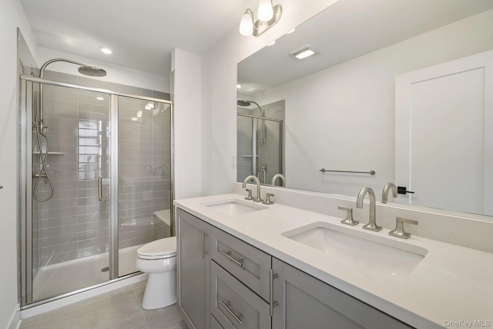 Primary Bathroom Bath featuring double vanity, a shower stall, and light tile patterned flooring Primary Bathroom Bath featuring double vanity, a shower stall, and light tile patterned flooring