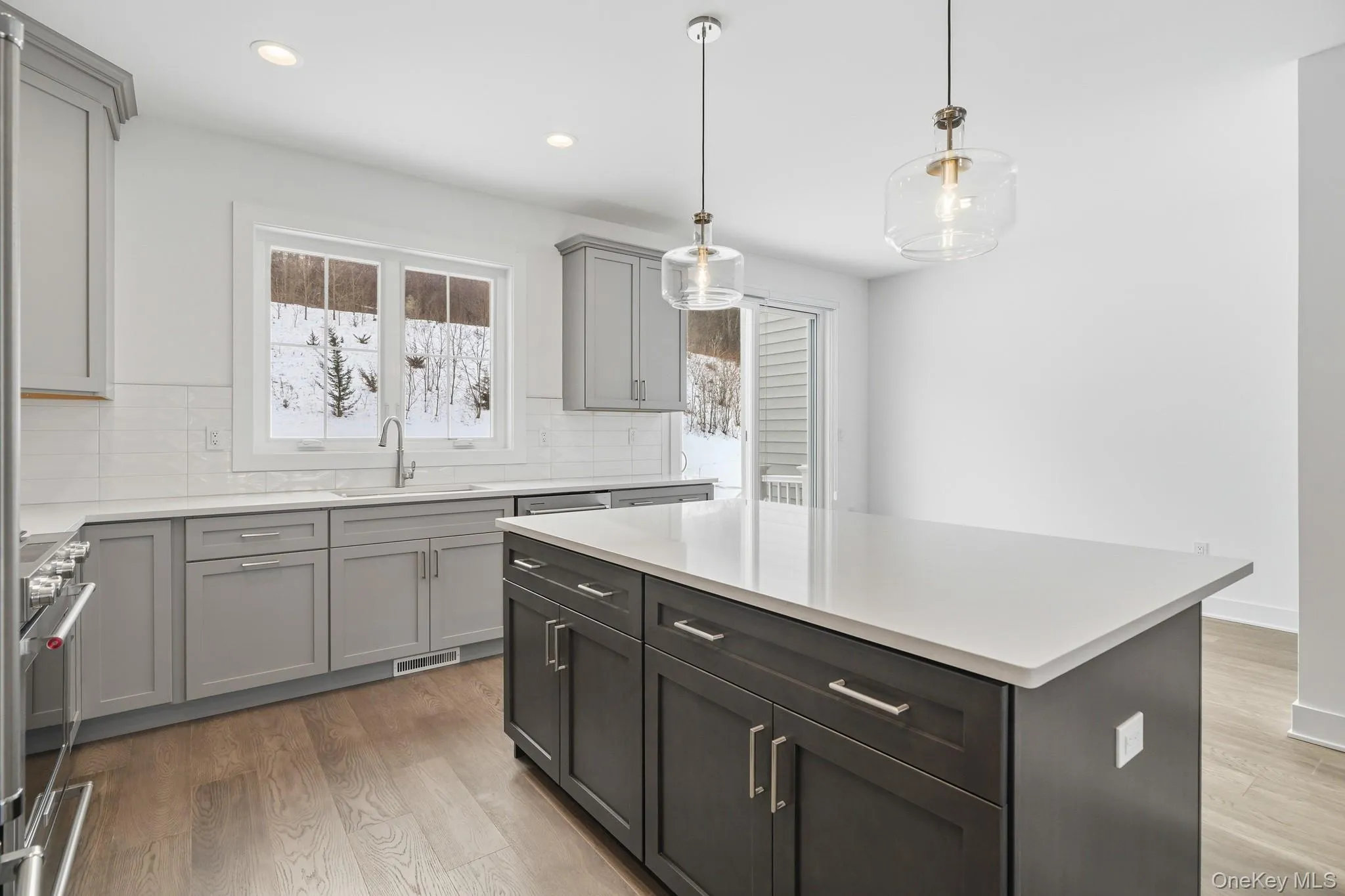 Kitchen featuring tasteful backsplash, pendant lighting, gray cabinets, stainless steel range oven, and recessed lighting Kitchen featuring tasteful backsplash, pendant lighting, gray cabinets, stainless steel range oven, and recessed lighting