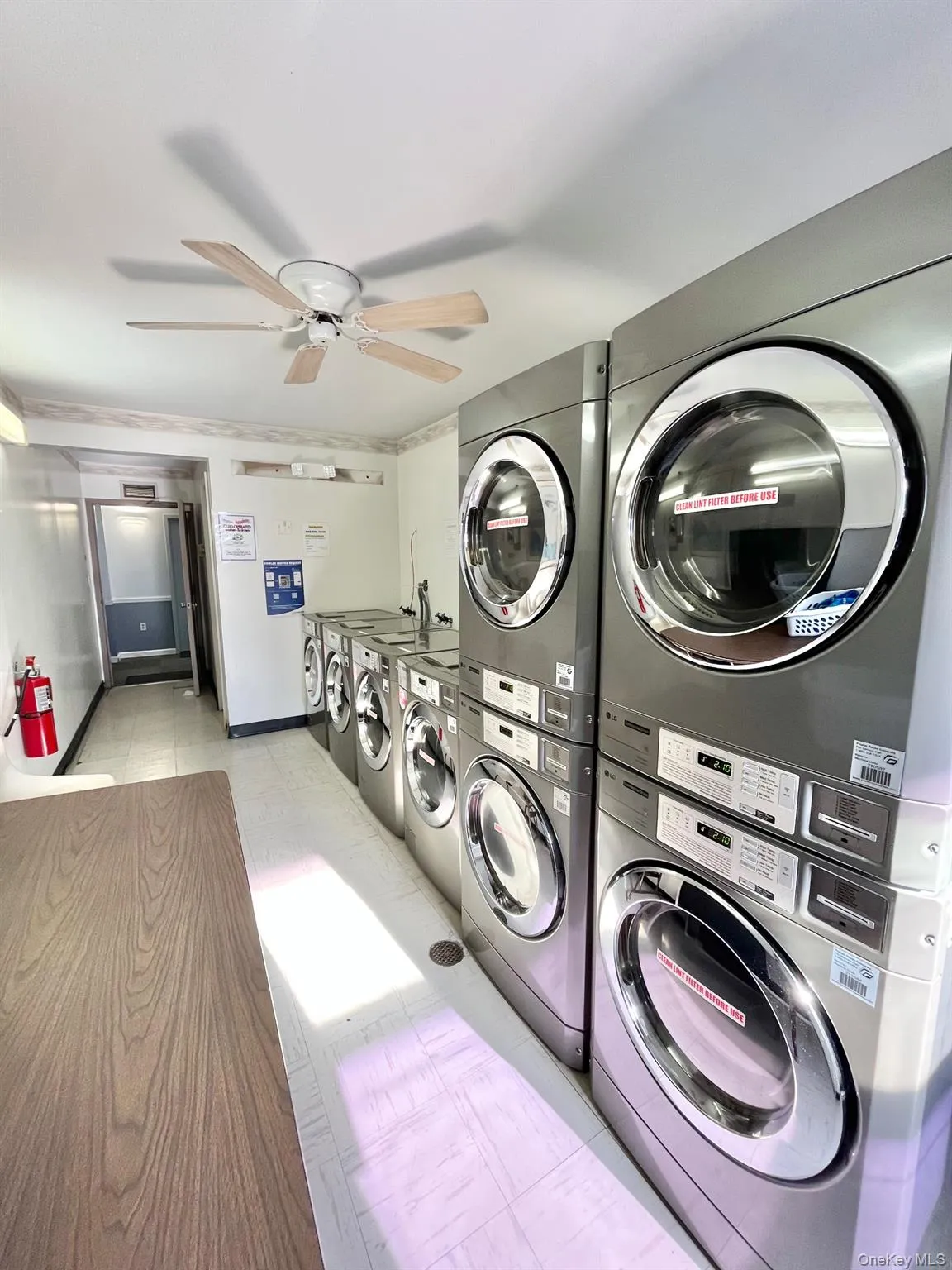 Shared laundry featuring stacked washer / drying machine, a ceiling fan, and washing machine and clothes dryer Shared laundry featuring stacked washer / drying machine, a ceiling fan, and washing machine and clothes dryer