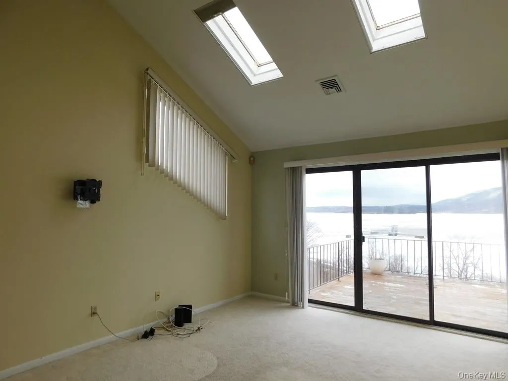 Primary bedroom with sliders to deck and Hudson River View Primary bedroom with sliders to deck and Hudson River View