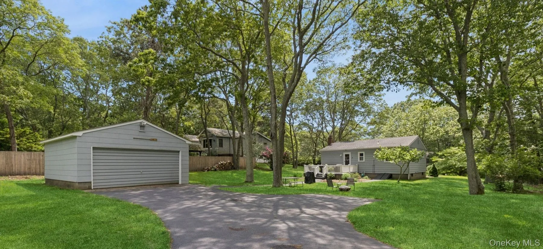 View of yard with a detached garage, an outdoor structure, and view of wooded area View of yard with a detached garage, an outdoor structure, and view of wooded area