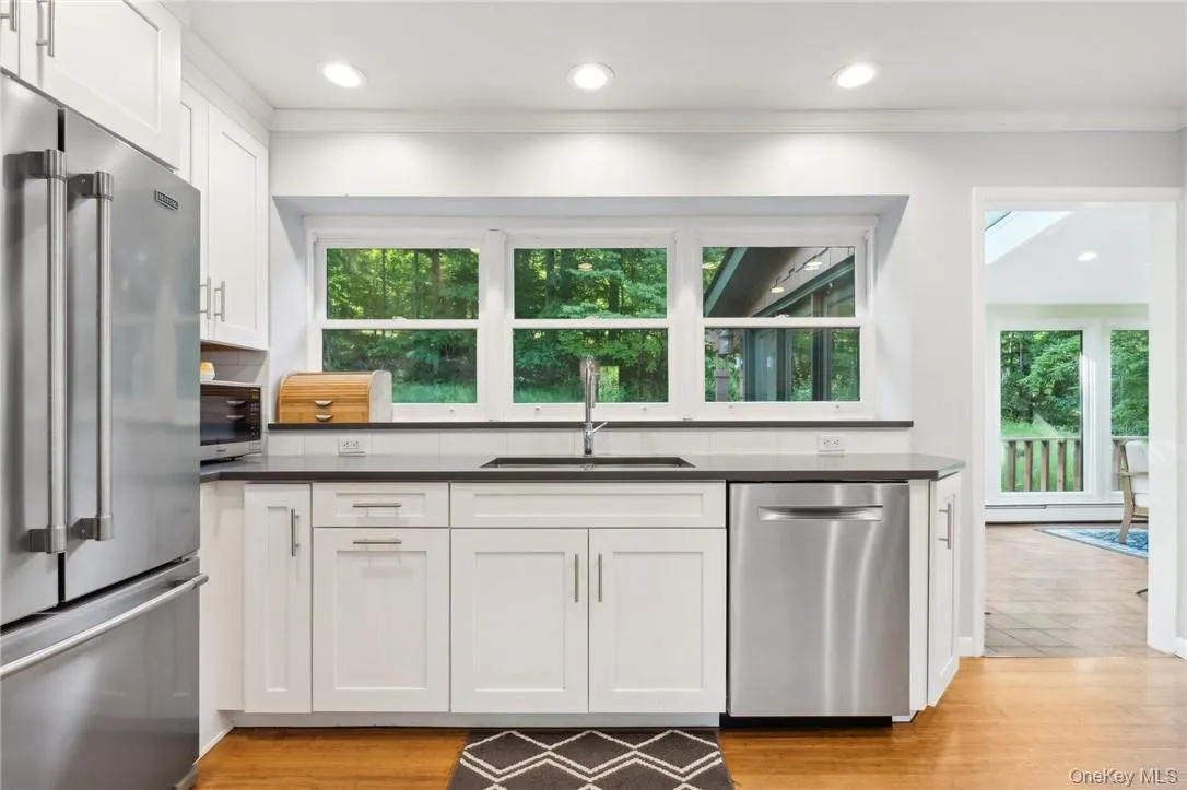 Kitchen featuring a healthy amount of sunlight, appliances with stainless steel finishes, sink, and white cabinets Kitchen featuring a healthy amount of sunlight, appliances with stainless steel finishes, sink, and white cabinets