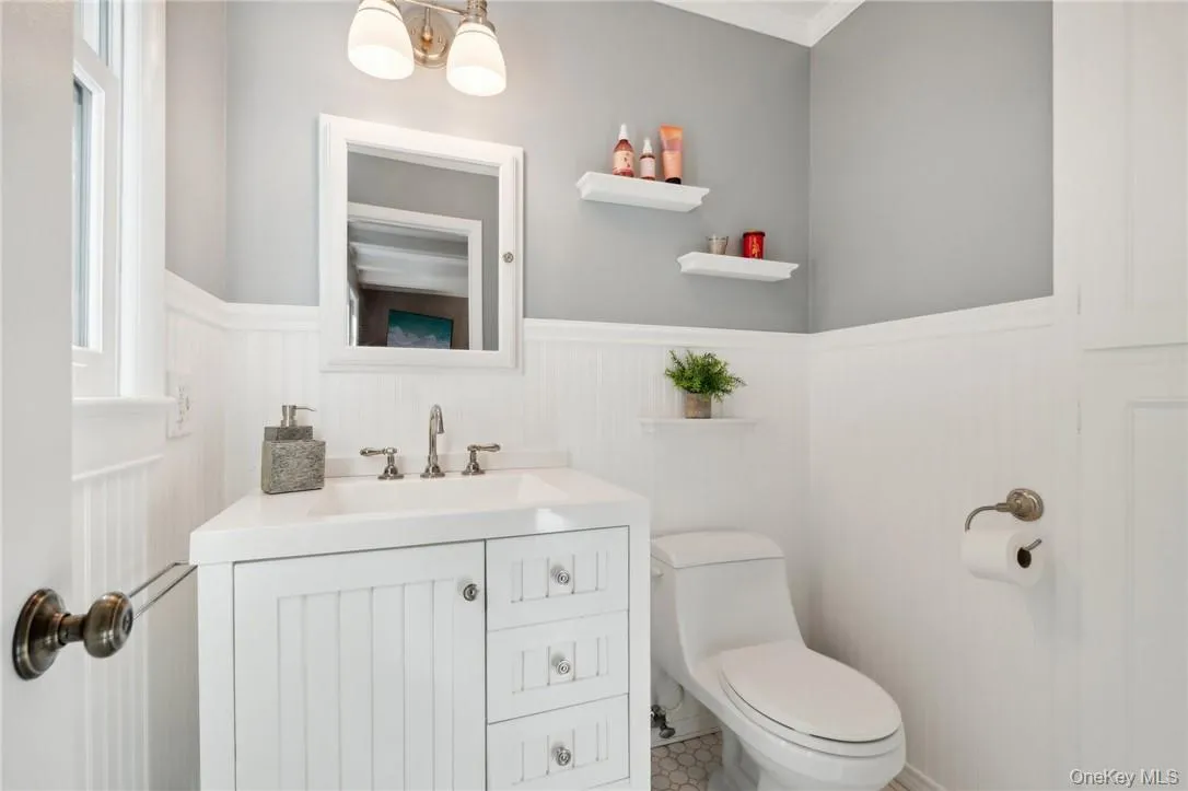 Bathroom with crown molding, tile flooring, vanity, and toilet Bathroom with crown molding, tile flooring, vanity, and toilet