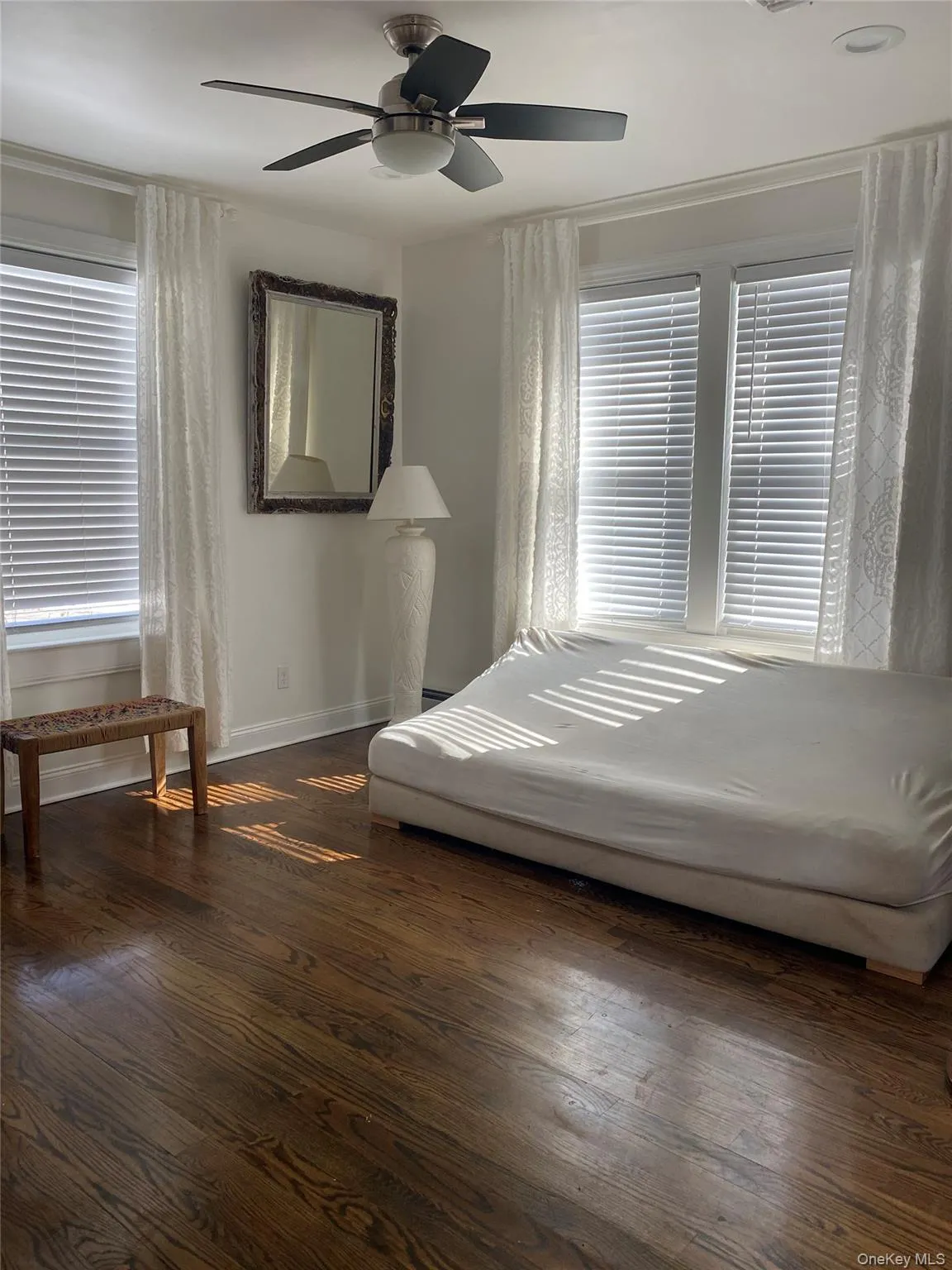 Bedroom with dark wood finished floors and a ceiling fan Bedroom with dark wood finished floors and a ceiling fan