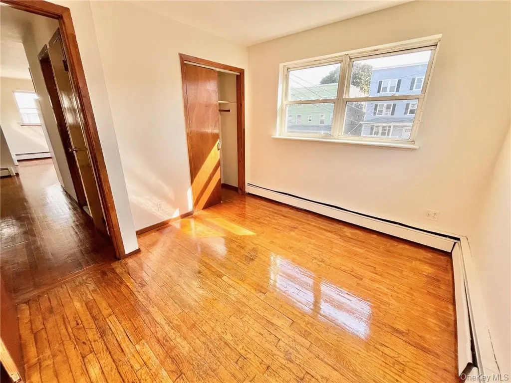 Spare room with light hardwood / wood-style floors and baseboard heating Spare room with light hardwood / wood-style floors and baseboard heating