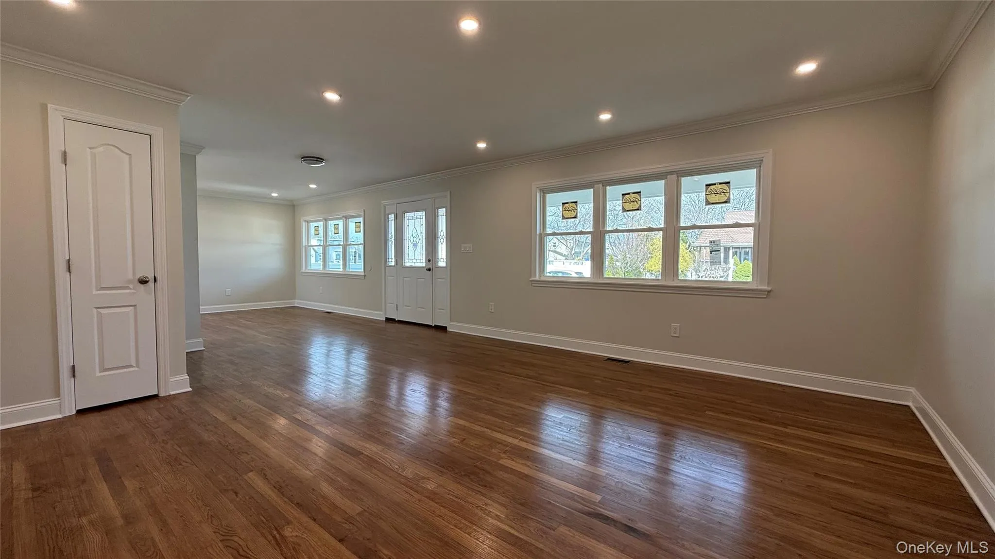 Living room with recessed lighting, wood flooring, and ornamental molding Living room with recessed lighting, wood flooring, and ornamental molding