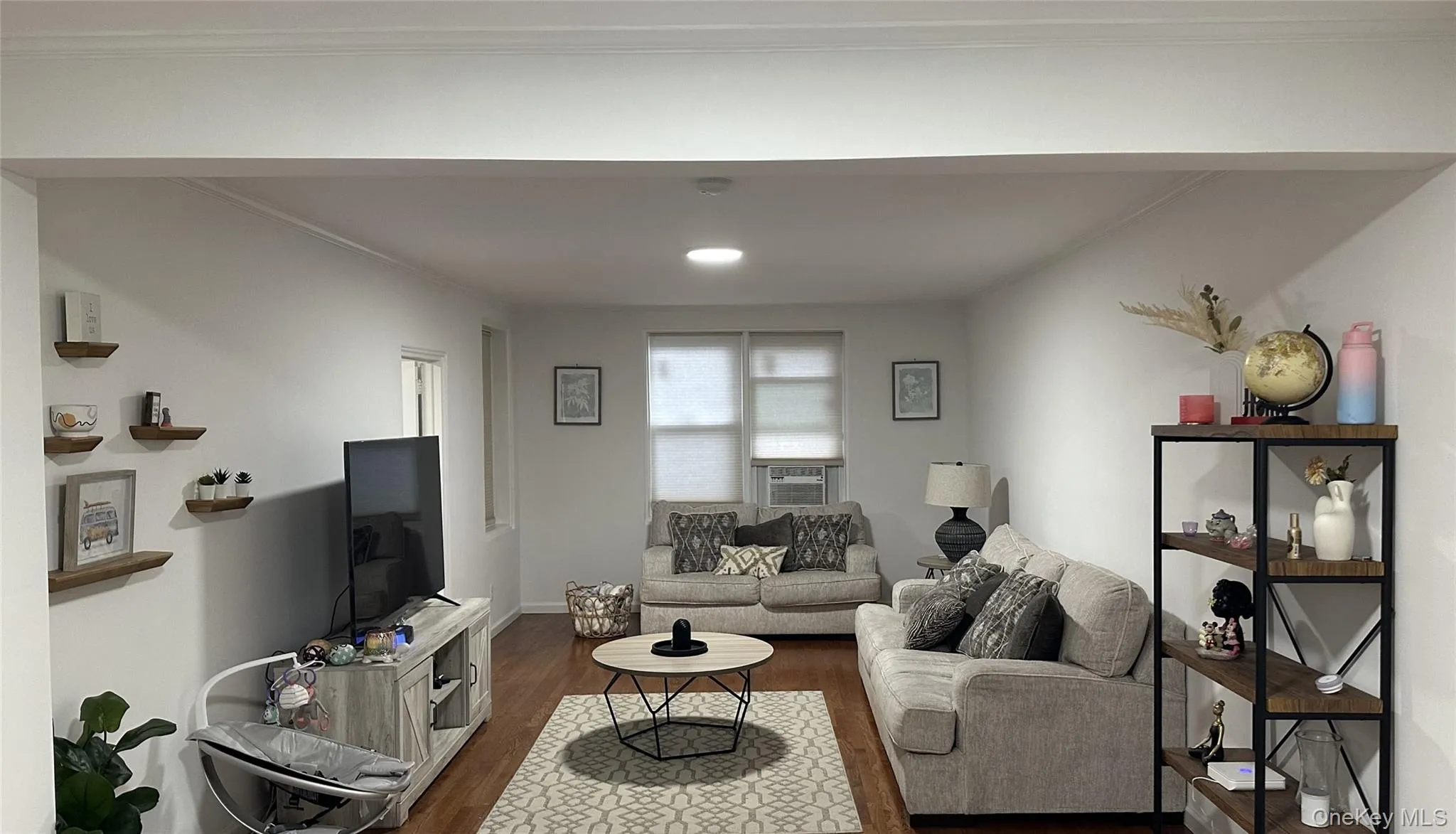 Living area with dark wood-type flooring, ornamental molding, and recessed lighting Living area with dark wood-type flooring, ornamental molding, and recessed lighting