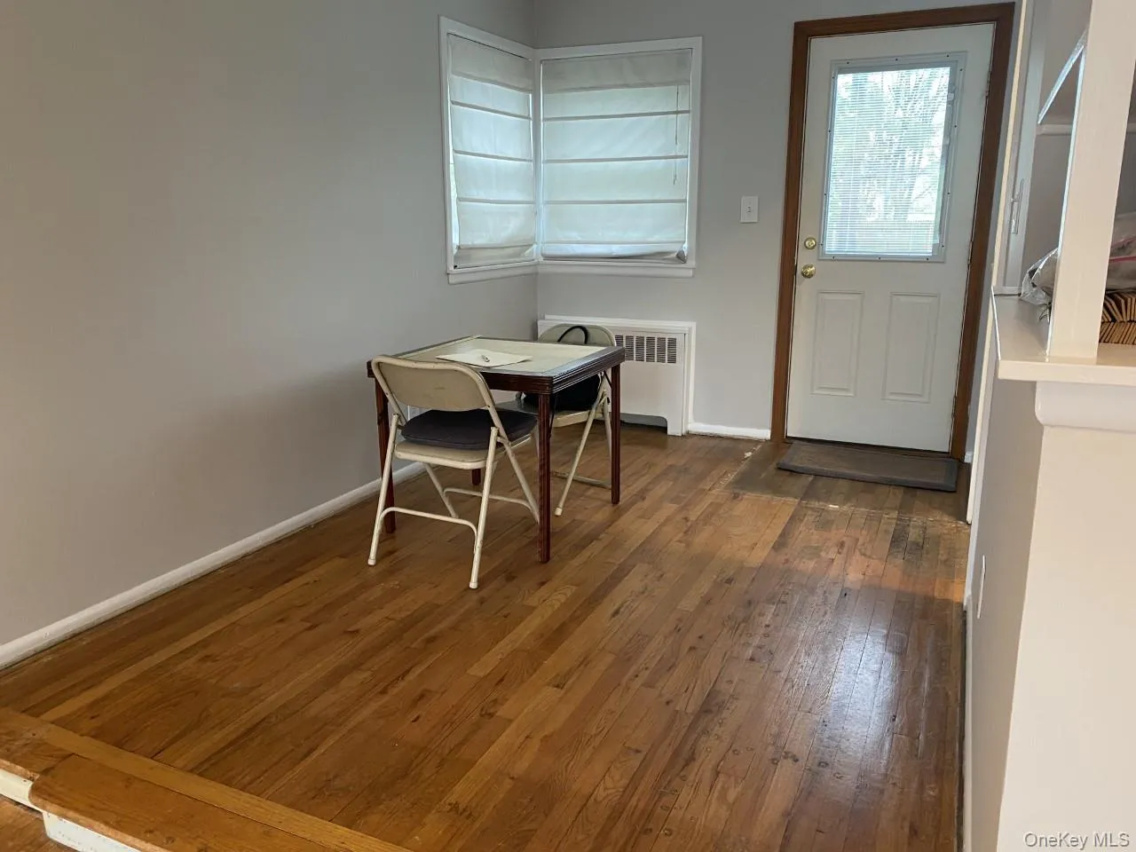 Dining area featuring hardwood flooring and radiator Dining area featuring hardwood flooring and radiator