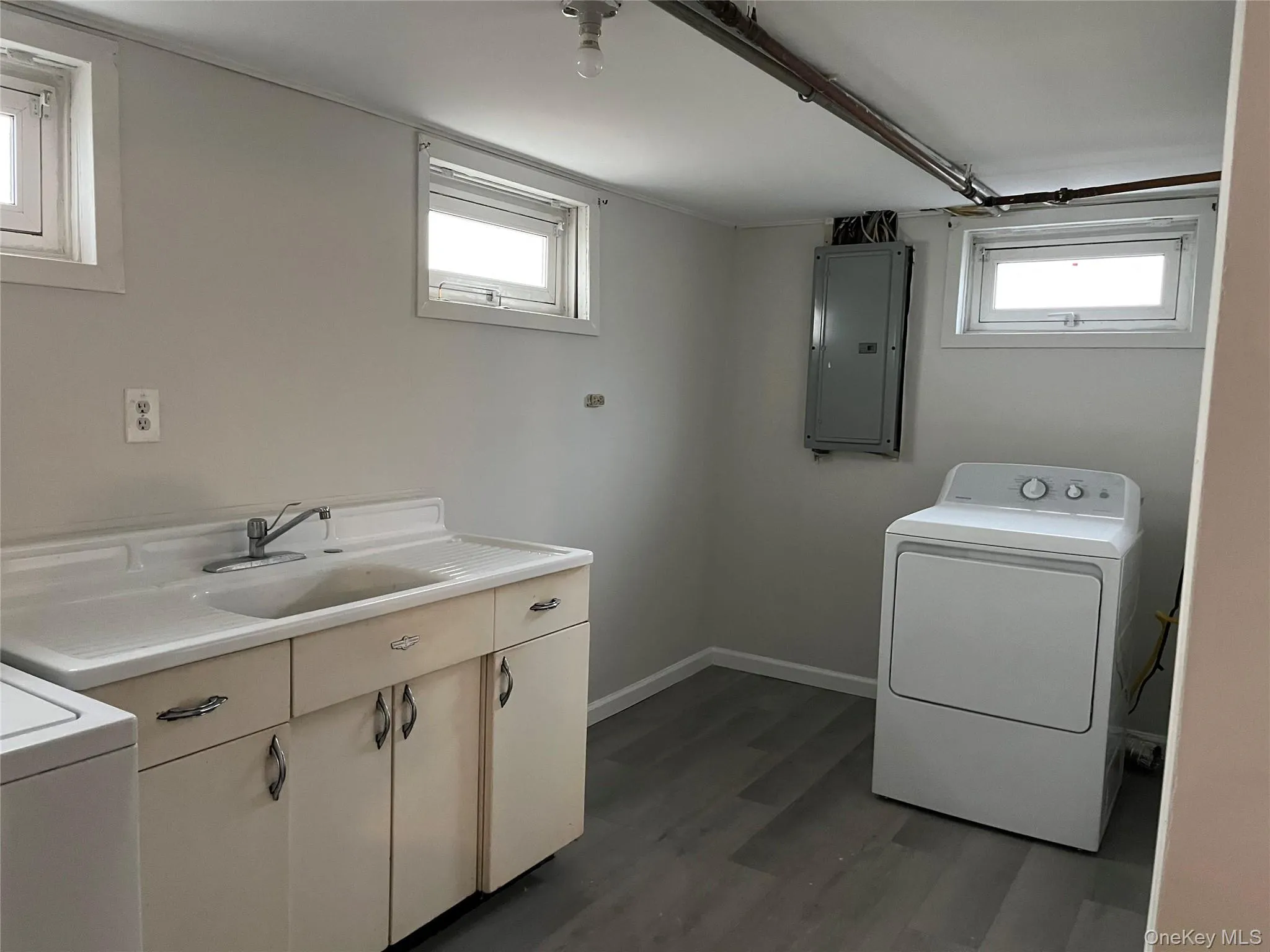 Laundry room with washer / dryer, electric panel, healthy amount of natural light, and vinyl planked floors Laundry room with washer / dryer, electric panel, healthy amount of natural light, and vinyl planked floors