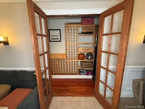 Wine room with french doors, wainscoting, and a decorative wall Wine room with french doors, wainscoting, and a decorative wall