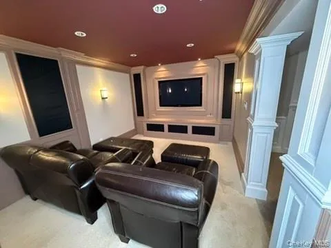 Cinema room, built in sound system, ornamental molding, ornate columns, light colored carpet, a decorative wall, and recessed lighting Cinema room, built in sound system, ornamental molding, ornate columns, light colored carpet, a decorative wall, and recessed lighting