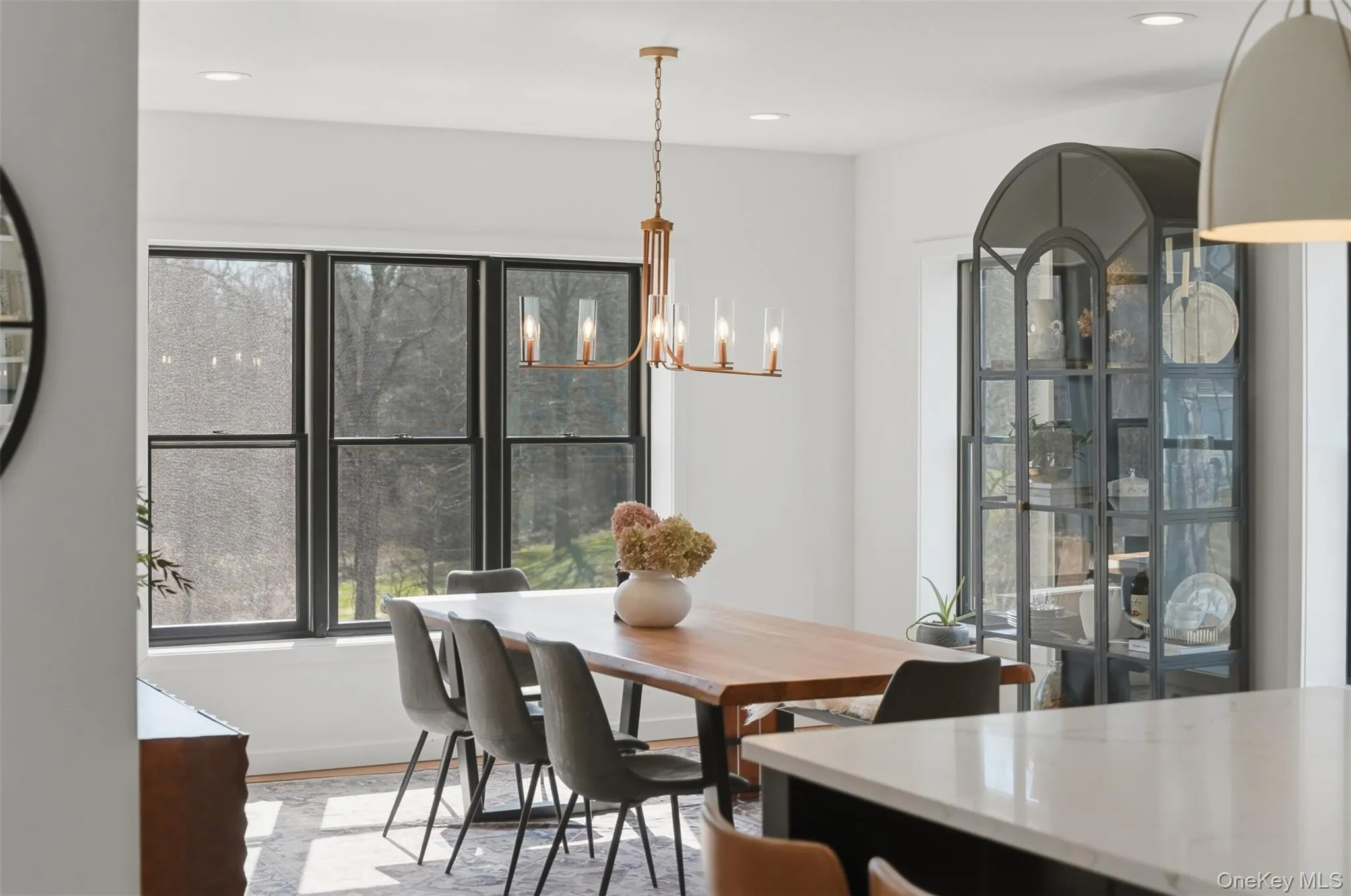 Sun drenched living room off the kitchen with elegant light fixture. Sun drenched living room off the kitchen with elegant light fixture.