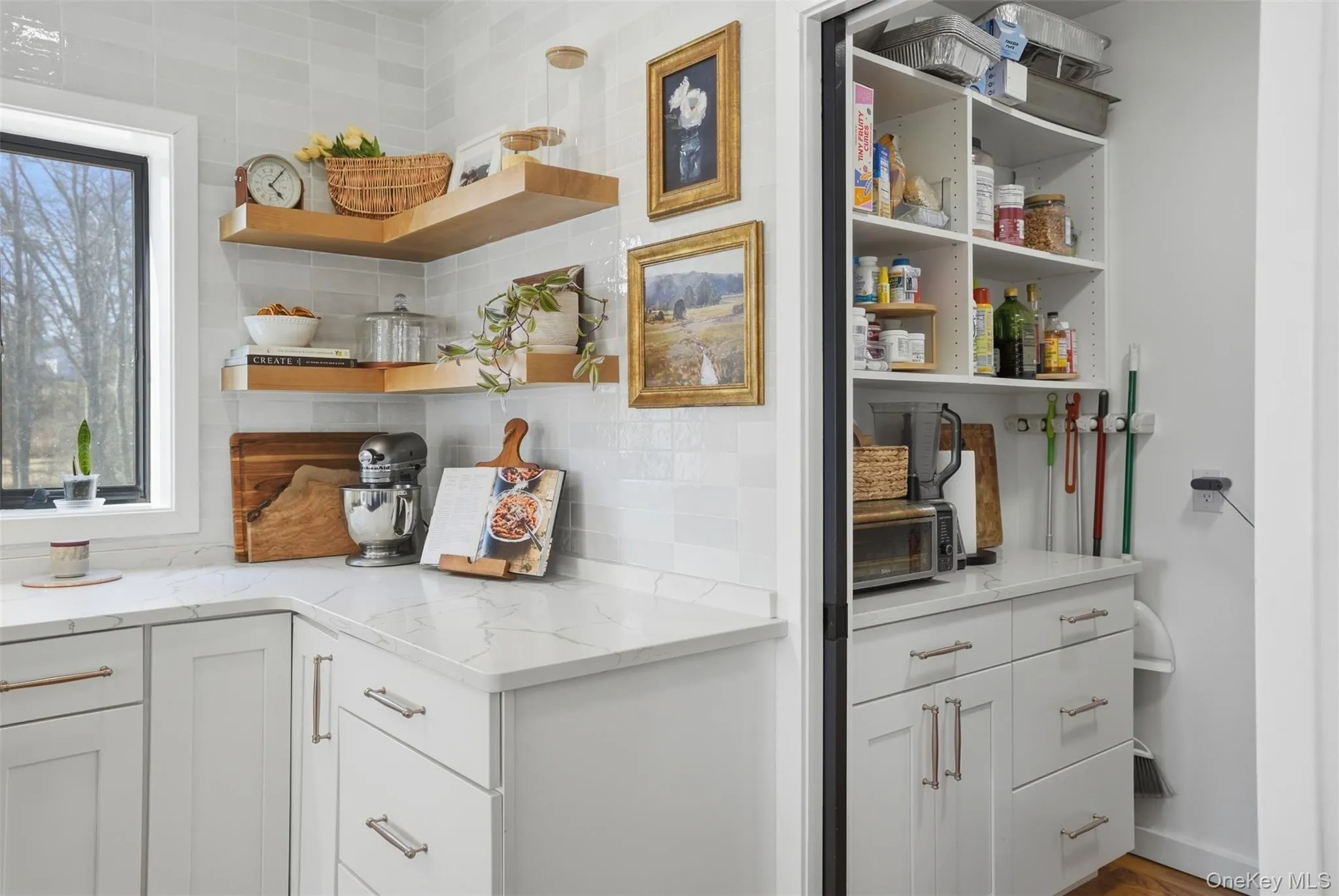 Outfitted pantry with outlets, counterspace and cabinets hidden behind stylish sliding doors Outfitted pantry with outlets, counterspace and cabinets hidden behind stylish sliding doors