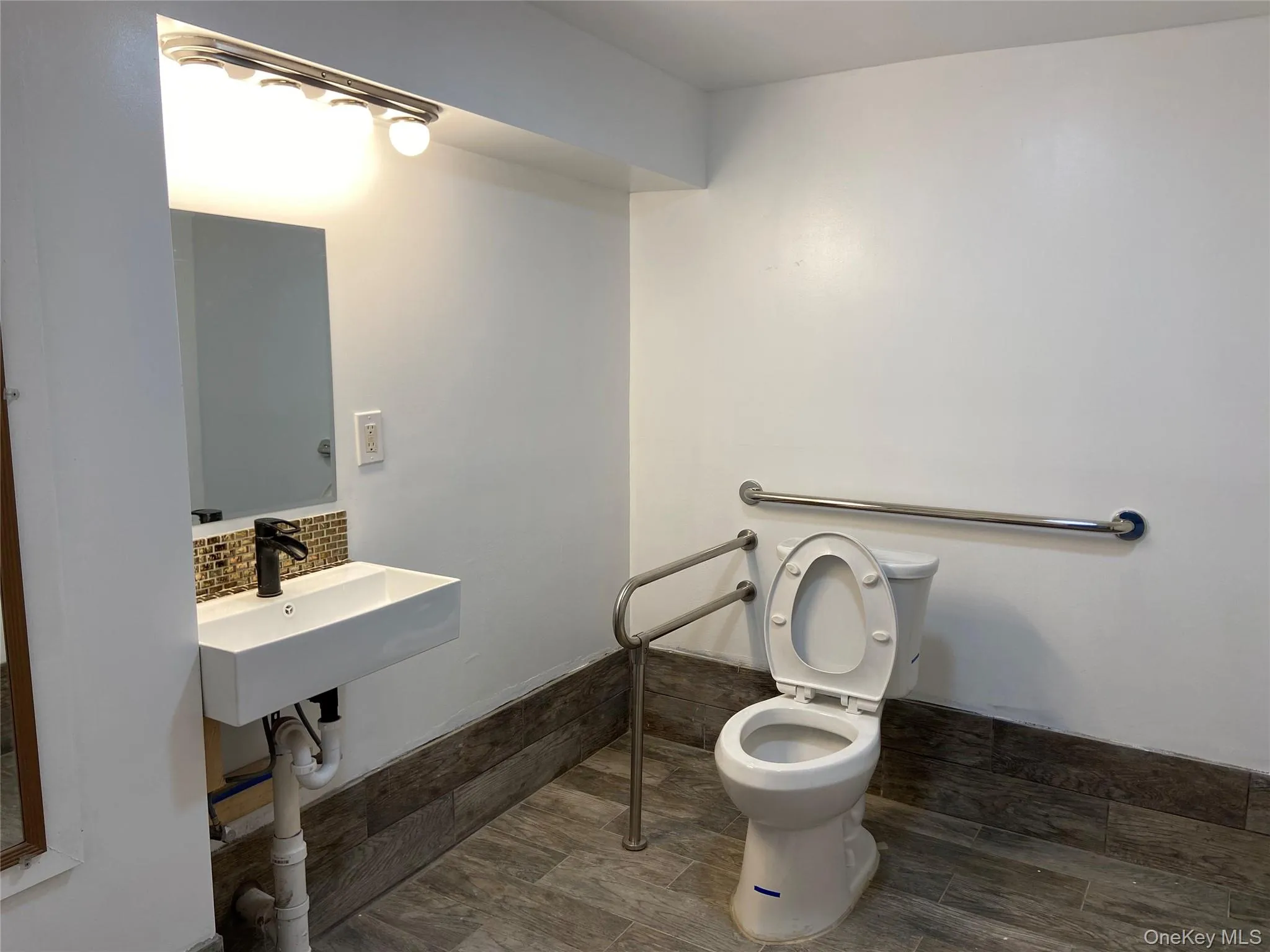 Bathroom featuring decorative backsplash and toilet Bathroom featuring decorative backsplash and toilet