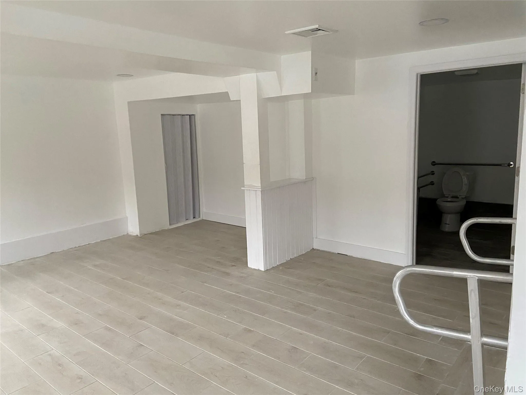 Unfurnished room with baseboards and light wood-type flooring Unfurnished room with baseboards and light wood-type flooring