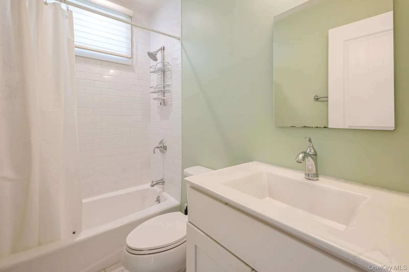 Full bathroom featuring vanity, toilet, and shower / tub combo with curtain Full bathroom featuring vanity, toilet, and shower / tub combo with curtain