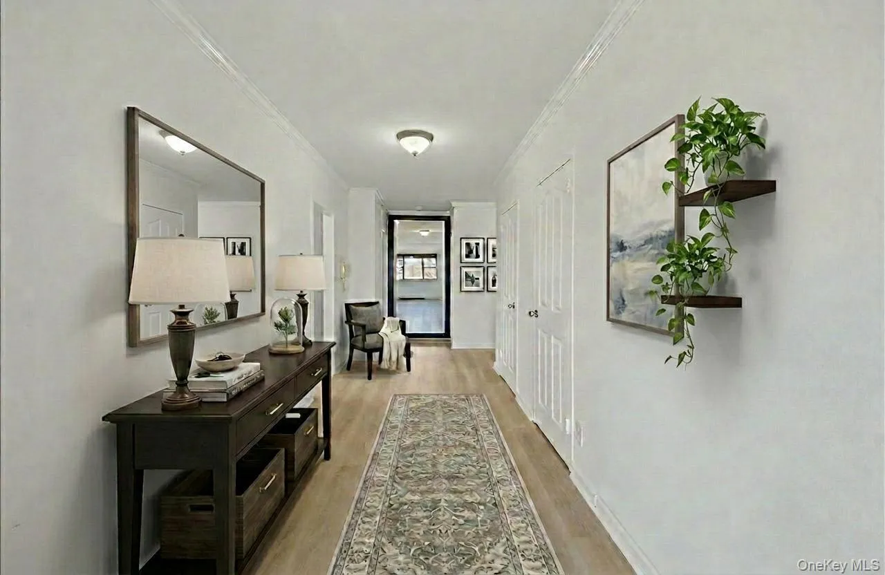 Staged hallway featuring light wood-style flooring and ornamental molding Staged hallway featuring light wood-style flooring and ornamental molding