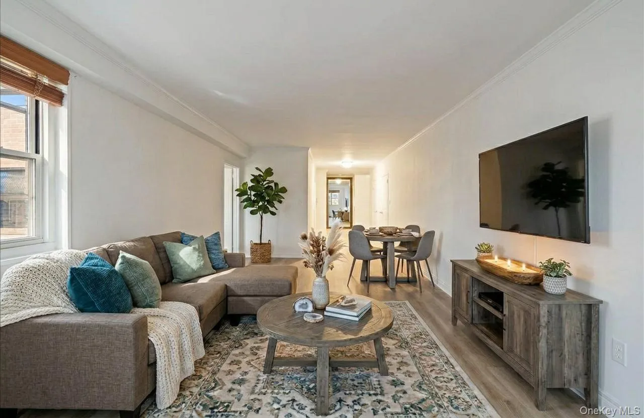 Open living/dining space with wood finished floors and crown molding Open living/dining space with wood finished floors and crown molding