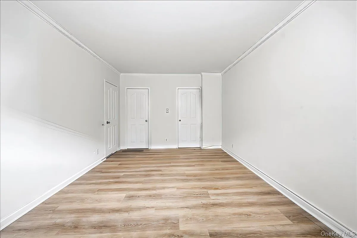 Unfurnished bedroom with light wood finished floors and crown molding Unfurnished bedroom with light wood finished floors and crown molding