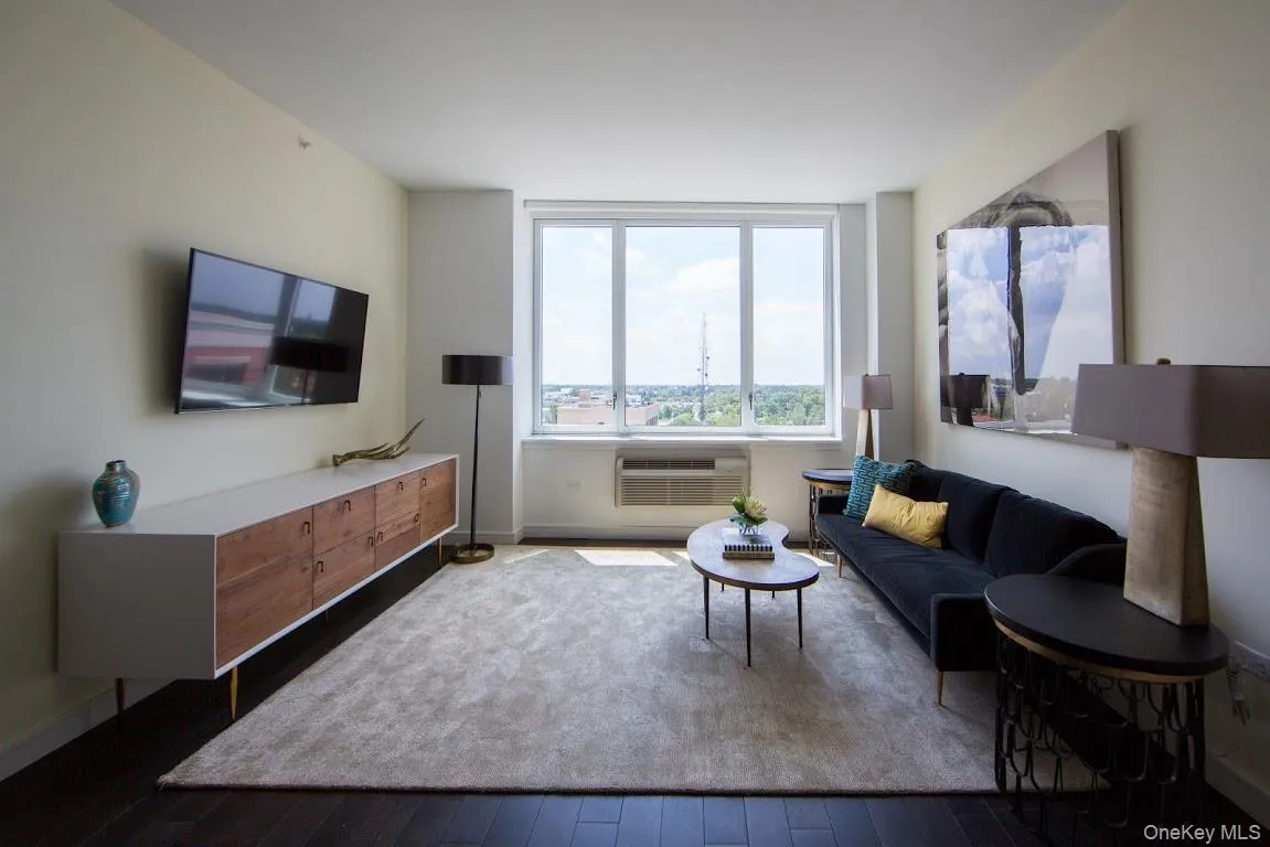Living area featuring a wall mounted air conditioner and hardwood / wood-style flooring Living area featuring a wall mounted air conditioner and hardwood / wood-style flooring