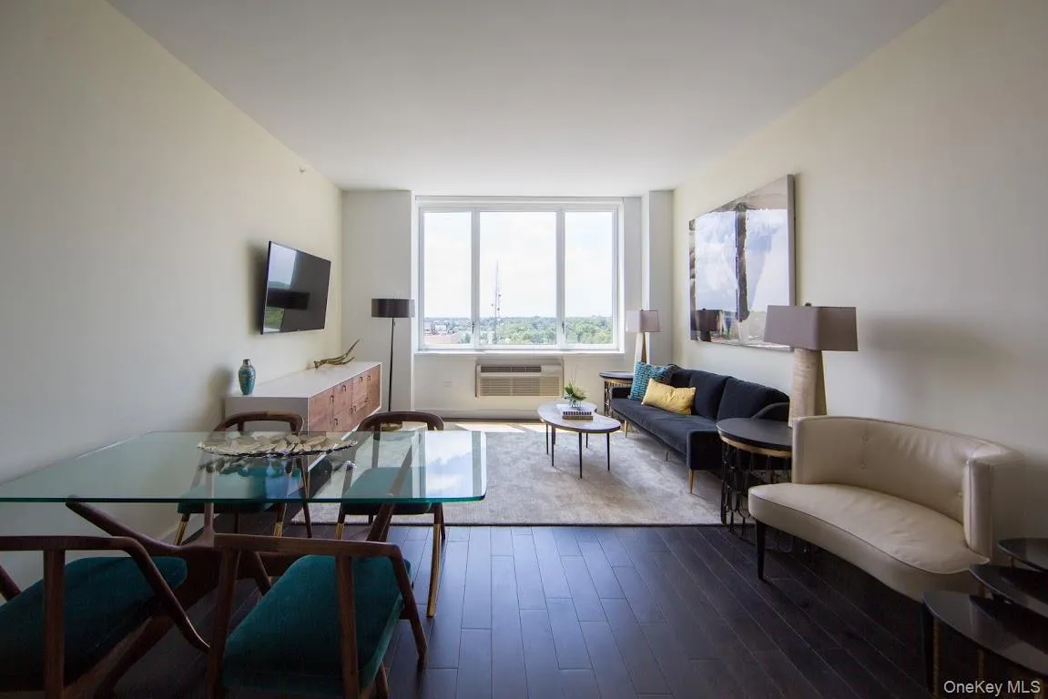 Living room featuring a wall mounted AC and dark wood-type flooring Living room featuring a wall mounted AC and dark wood-type flooring