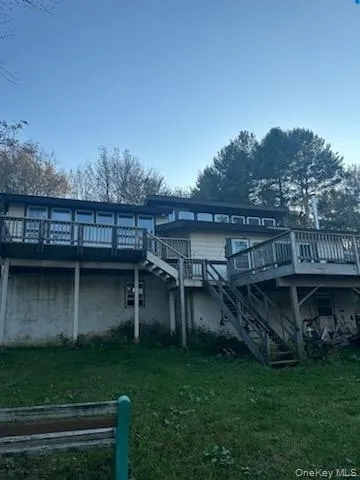 Rear view of house with a deck and a yard Rear view of house with a deck and a yard