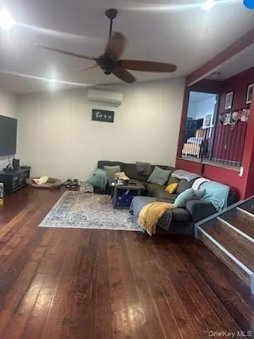 Living room with dark wood-style flooring and ceiling fan Living room with dark wood-style flooring and ceiling fan