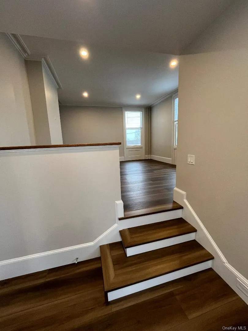 View from kitchen looking into living room with three steps up. View from kitchen looking into living room with three steps up.