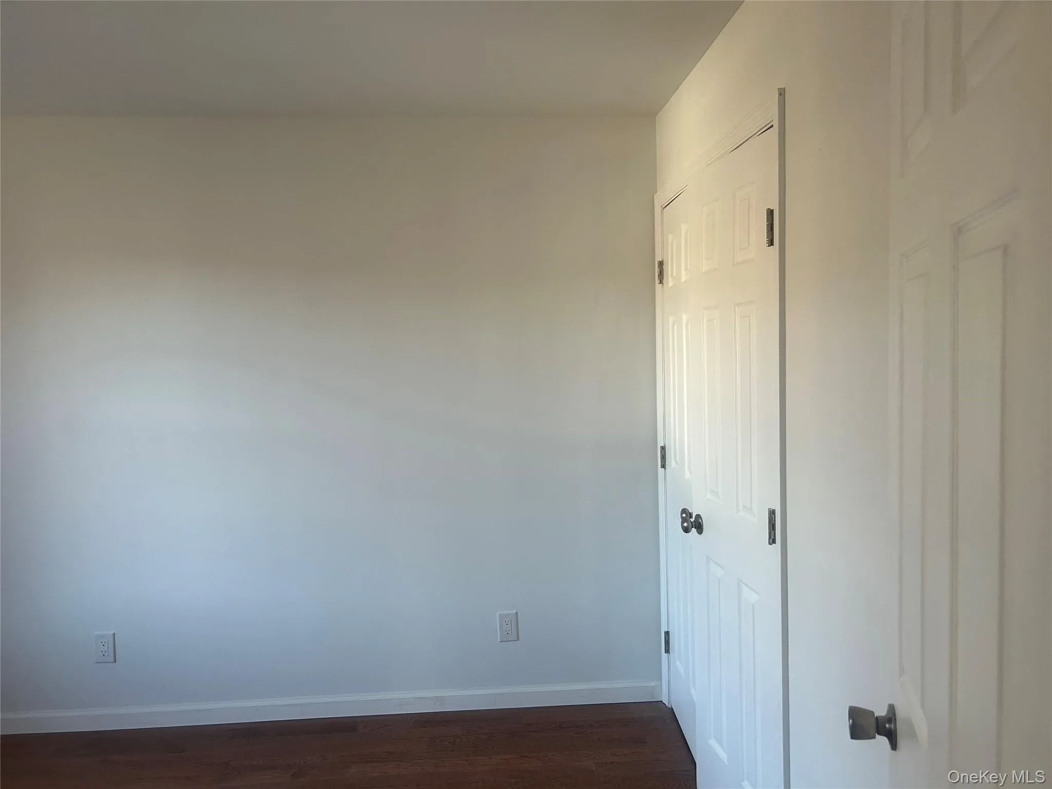 Unfurnished bedroom with dark wood-style flooring and a closet Unfurnished bedroom with dark wood-style flooring and a closet