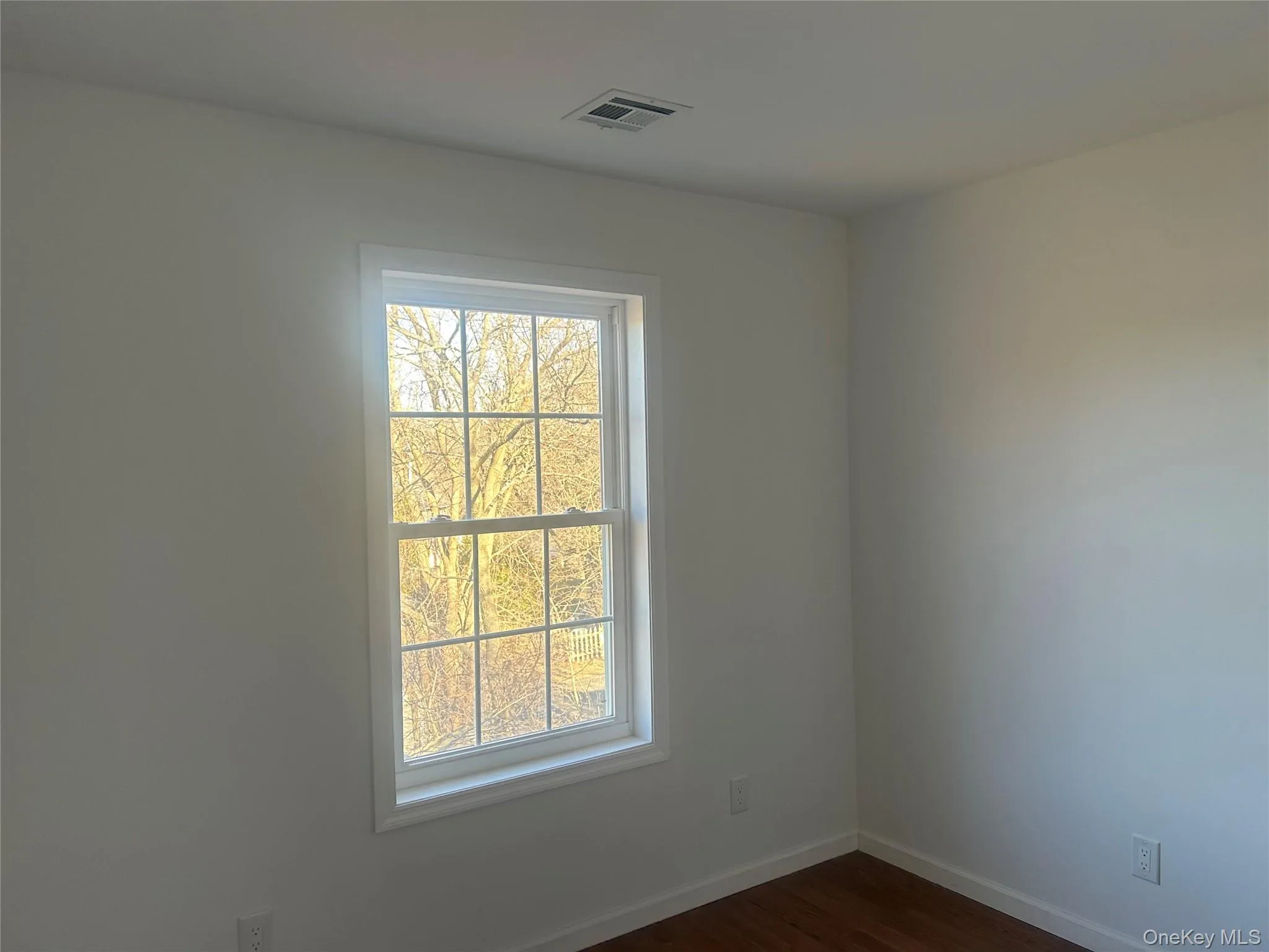 Unfurnished room featuring baseboards and dark wood-style floors Unfurnished room featuring baseboards and dark wood-style floors