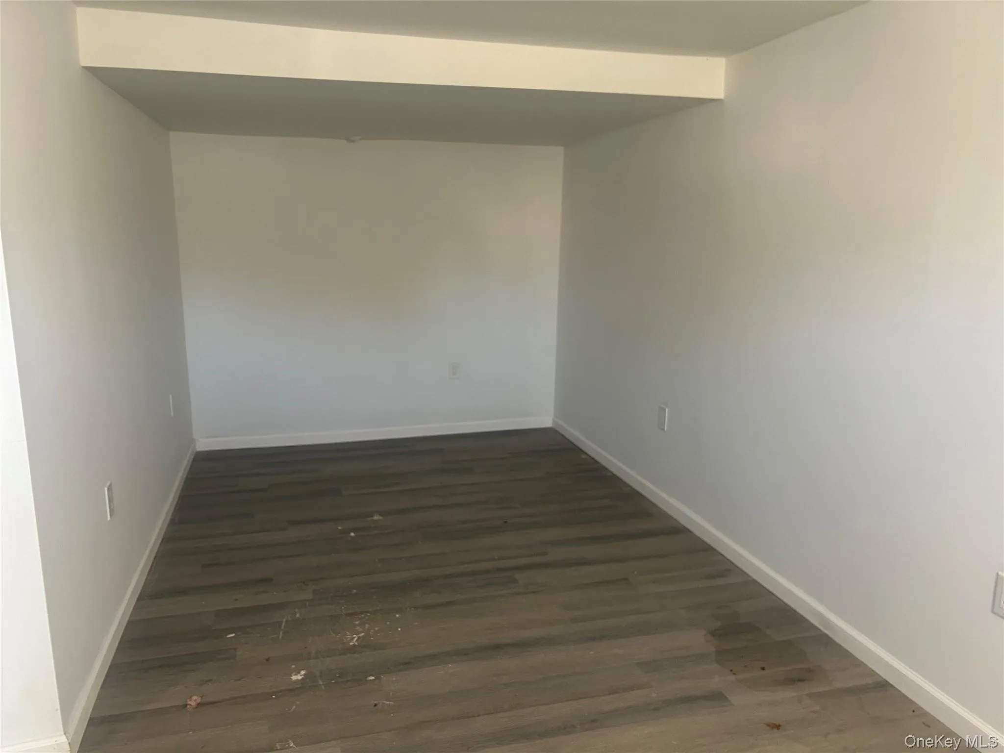 Unfurnished room with dark wood-type flooring Unfurnished room with dark wood-type flooring