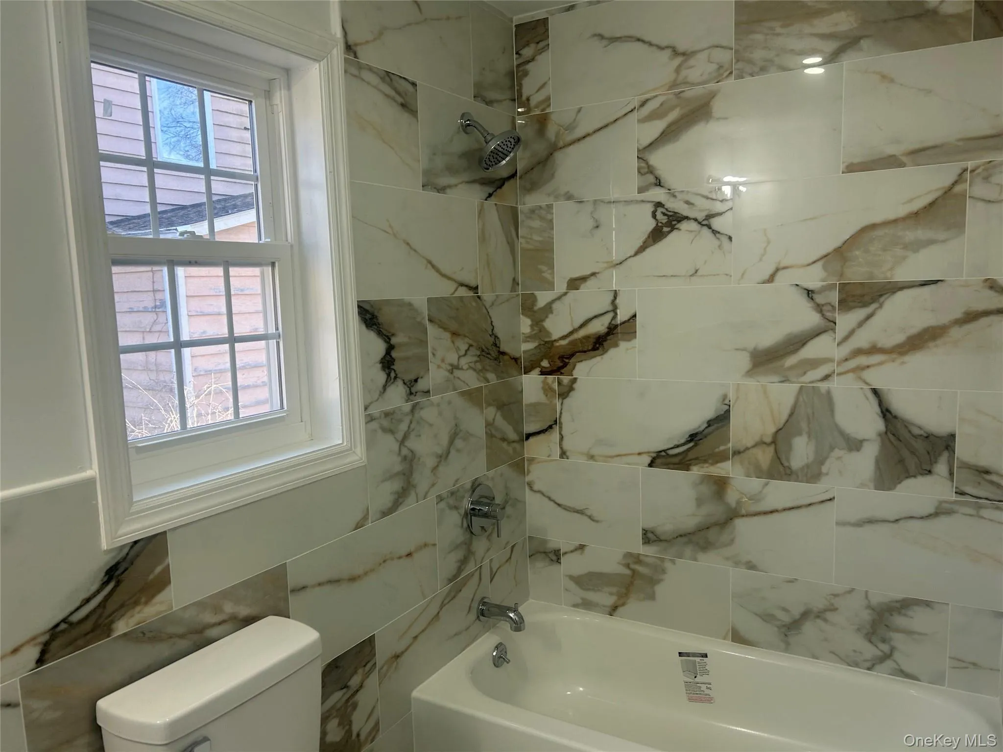 Full bath featuring healthy amount of natural light and tub / shower combination Full bath featuring healthy amount of natural light and tub / shower combination