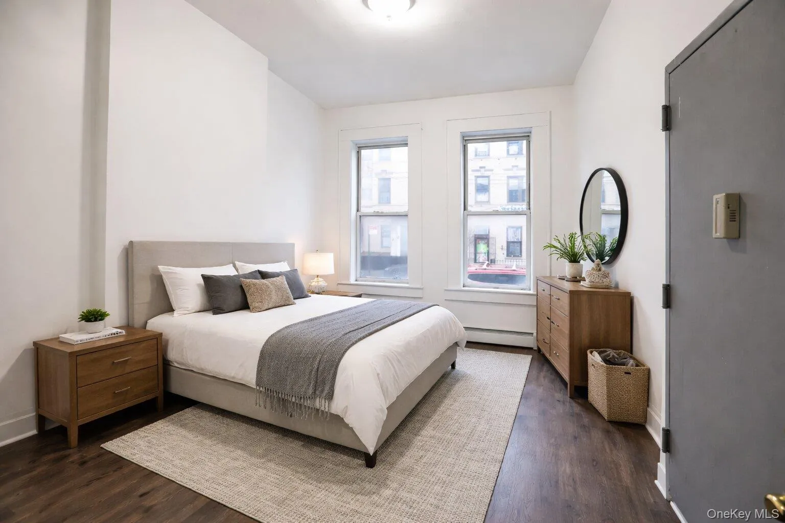 Virtually staged bedroom featuring rich dark wood flooring and light-colored walls Virtually staged bedroom featuring rich dark wood flooring and light-colored walls