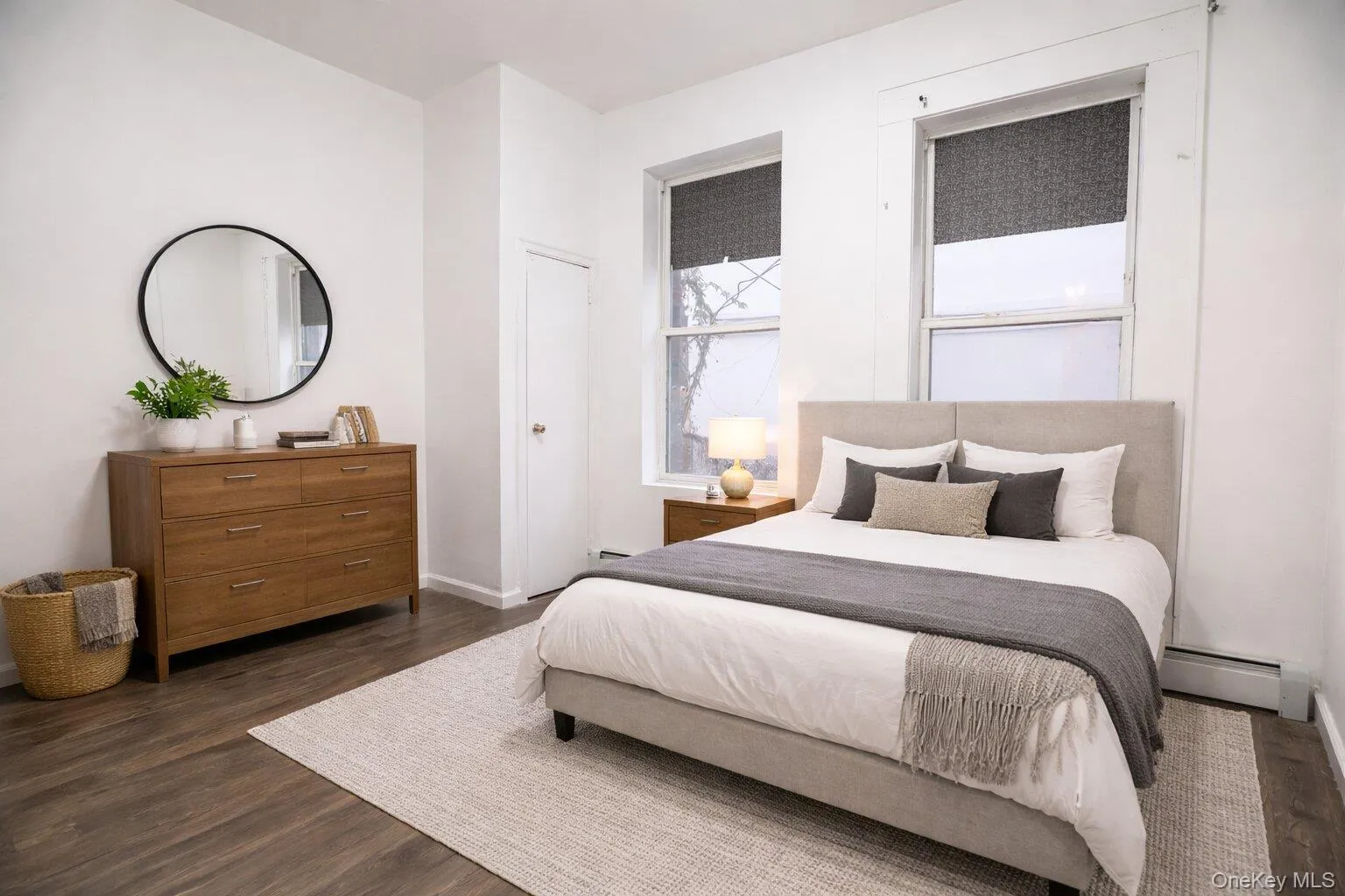 Virtually staged bedroom featuring hardwood floors, white walls, and two large windows allowing for natural illumination Virtually staged bedroom featuring hardwood floors, white walls, and two large windows allowing for natural illumination