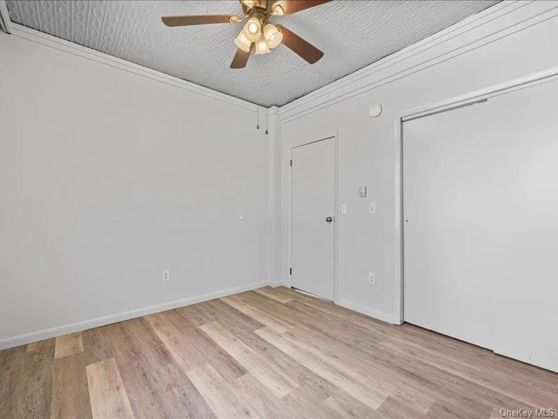 Spare room featuring light wood-style flooring, ceiling fan, and baseboards Spare room featuring light wood-style flooring, ceiling fan, and baseboards