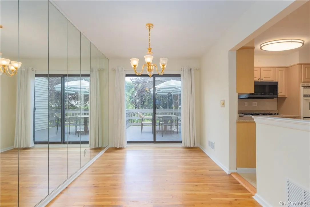 Unfurnished dining area with light hardwood / wood-style floors and an inviting chandelier Unfurnished dining area with light hardwood / wood-style floors and an inviting chandelier