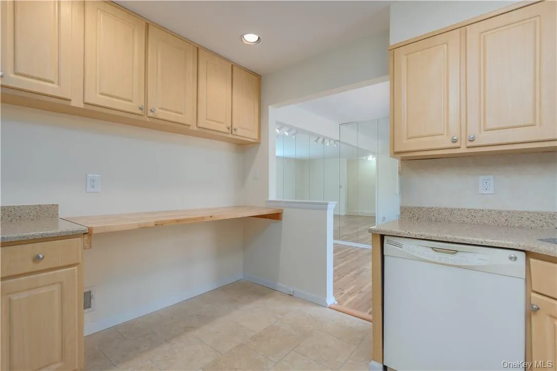 Kitchen featuring dishwasher, light brown cabinetry, light stone countertops, and light wood-type flooring Kitchen featuring dishwasher, light brown cabinetry, light stone countertops, and light wood-type flooring