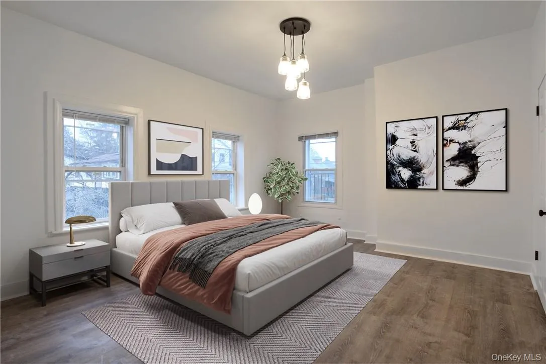Bedroom featuring baseboards and wood finished floors Bedroom featuring baseboards and wood finished floors