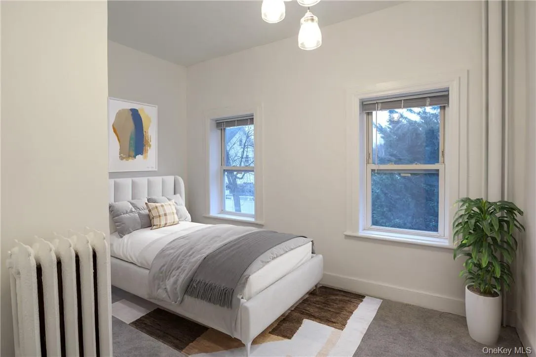 Bedroom with radiator heating unit and light carpet Bedroom with radiator heating unit and light carpet