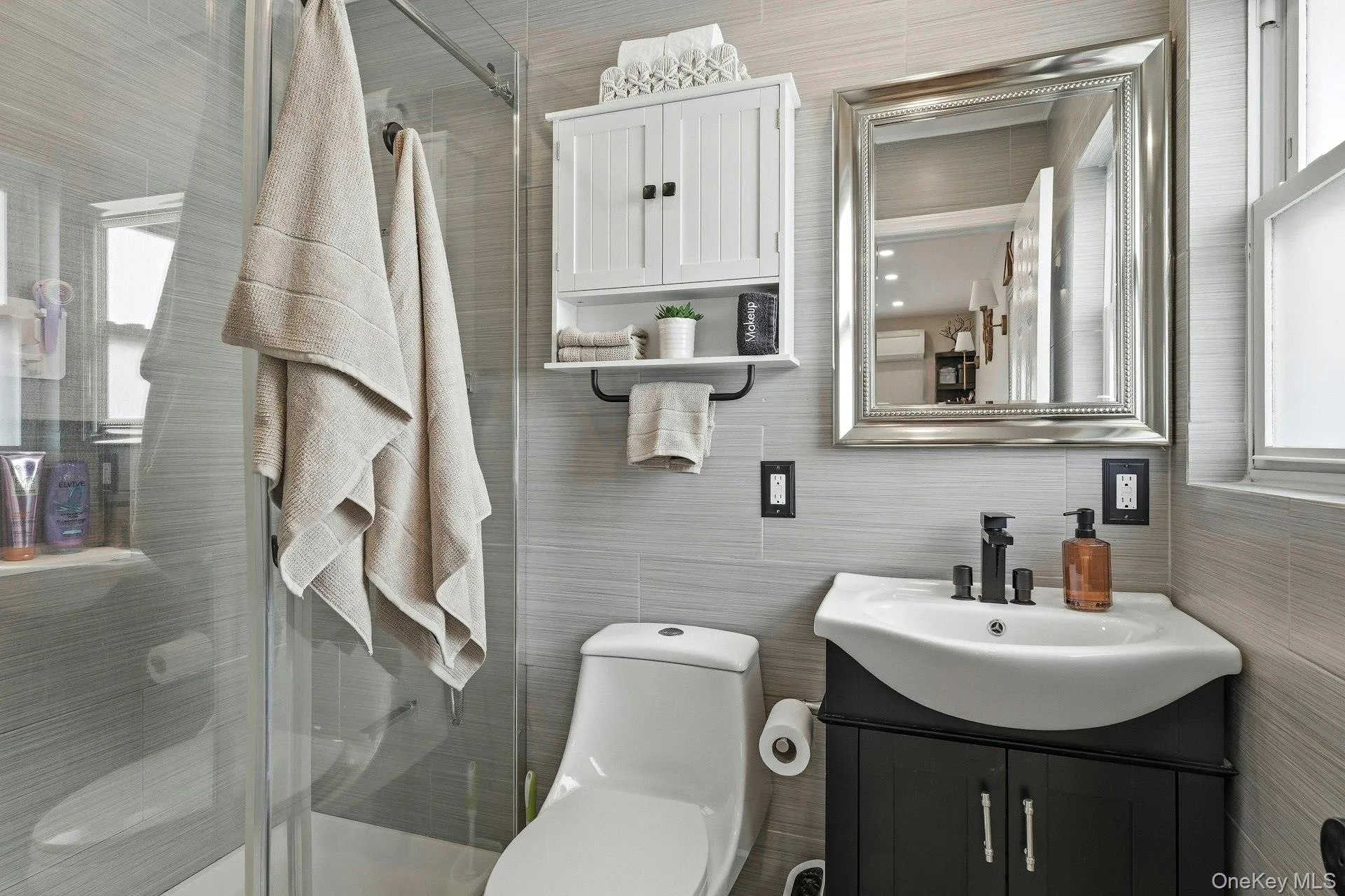 Bathroom with vanity, tile walls, and a stall shower Bathroom with vanity, tile walls, and a stall shower