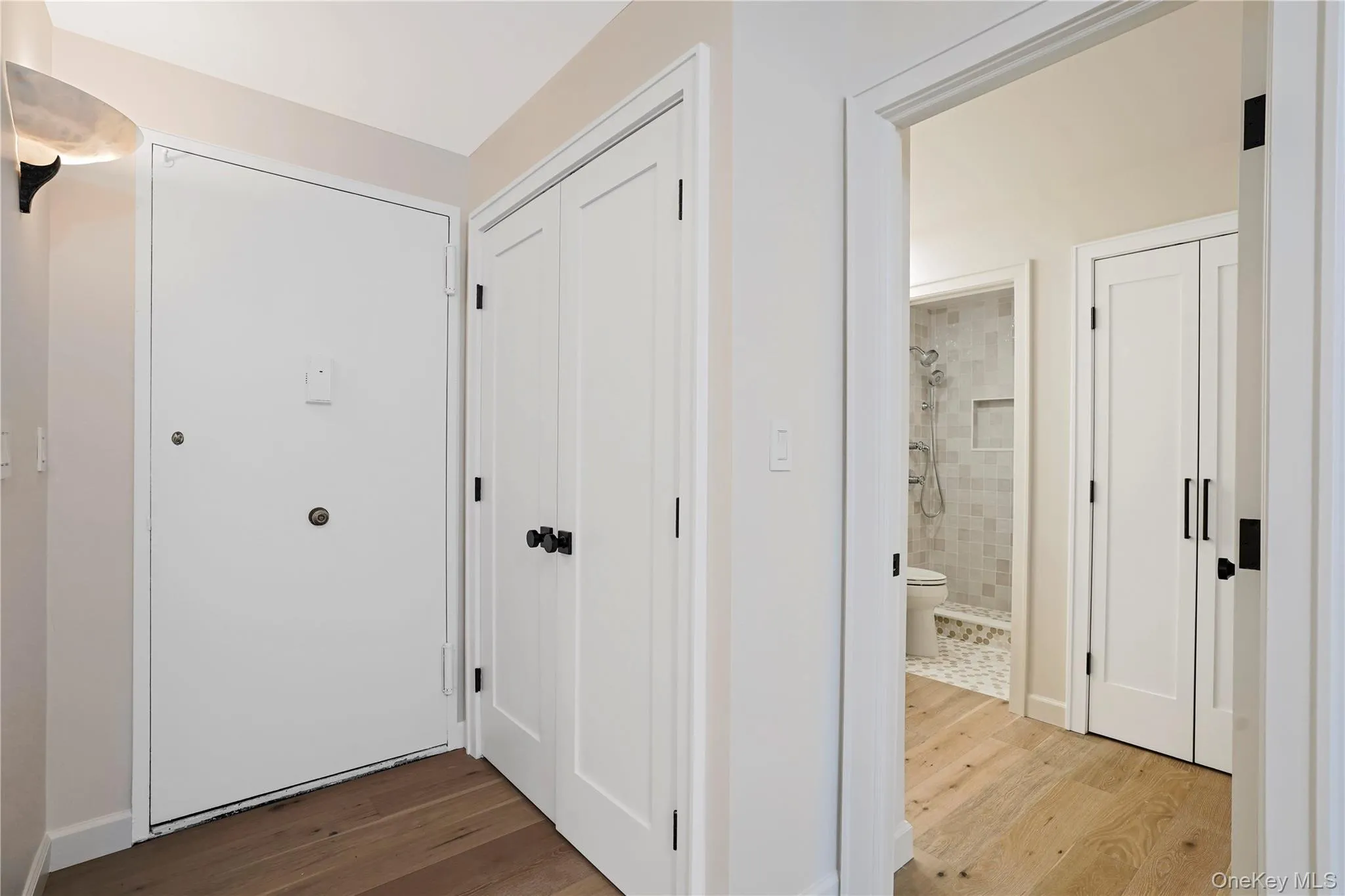 Entrance foyer with solid wood doors and white flooring Entrance foyer with solid wood doors and white flooring