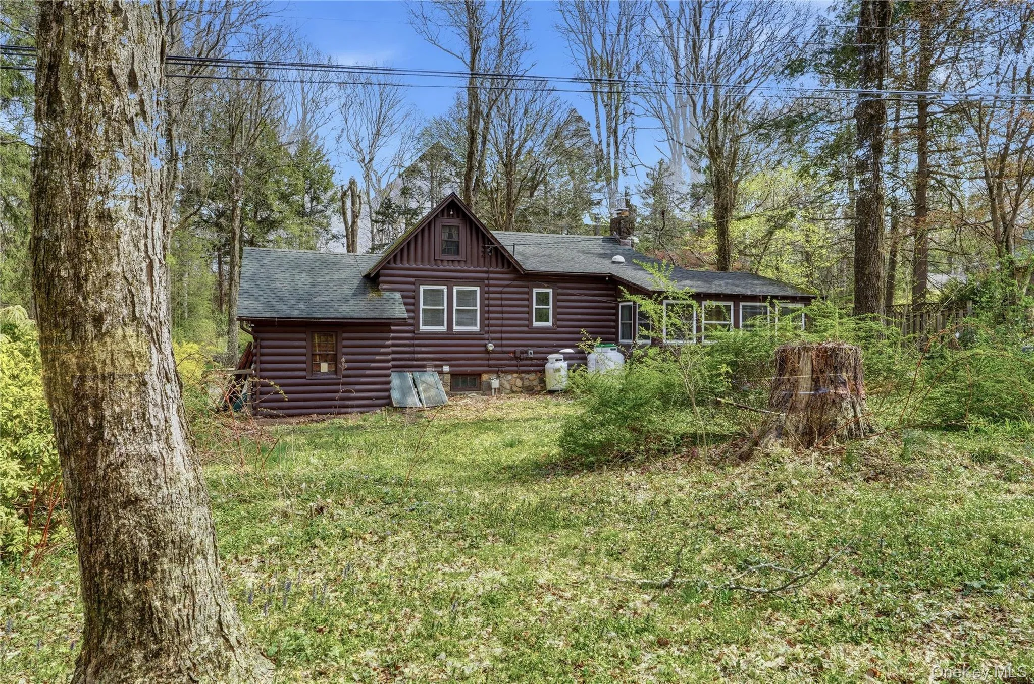 The property features a log cabin style exterior with white-trimmed windows. The property features a log cabin style exterior with white-trimmed windows.